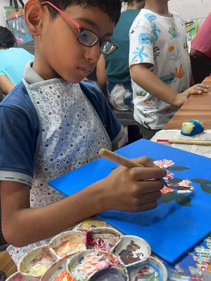 Using a palette knife, this young artist is learning to create textured flowers. Our kids' canvas courses often introduce different tools to make painting more exciting.
