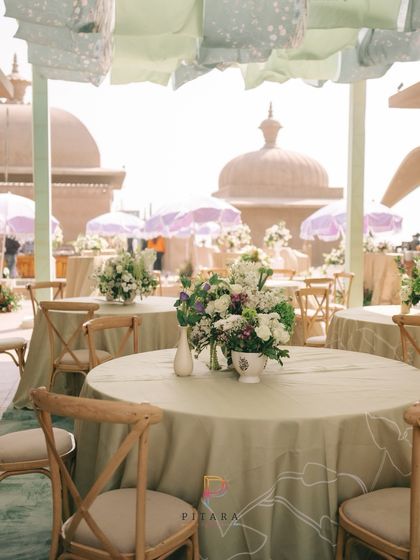 A closer look at the pastel green dining setup, with the heritage domes in the background adding a touch of grandeur to the breezy, daytime event.