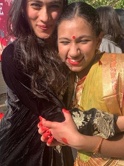 A warm hug with a student, her hands still colored with red alta from the performance. This picture captures the pure joy and emotion of the day.