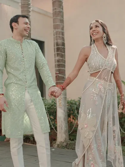 The couple walking hand-in-hand, all smiles, during their Haldi event. Their happiness is our ultimate goal.
