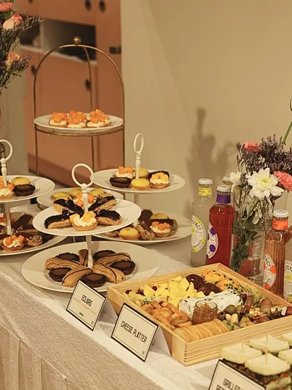 Here is another view of the elegant spread I created for a corporate client. The display features tiered platters with a variety of my signature eclairs, tarts, and a cheese board, all beautifully arranged with floral accents to create a visually stunning centerpiece.