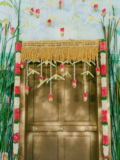 A deconstructed mandap concept. We used a painted backdrop of reeds and a doorway adorned with woven coconut leaves and flowers to create a minimalist yet symbolic ceremony space.