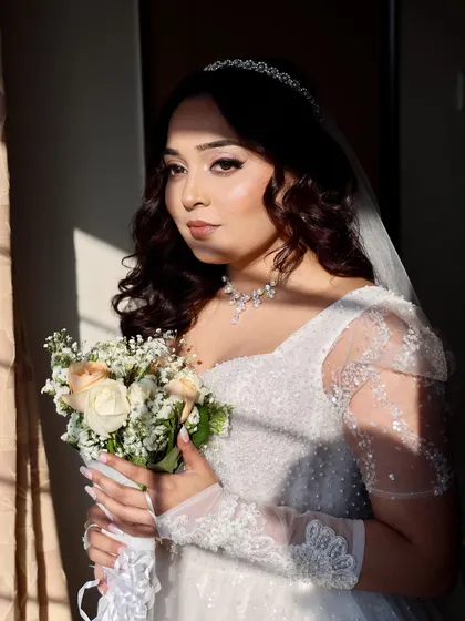 Sunkissed and stunning. The natural light pouring in creates a beautiful effect on Shirley's full glam makeup, highlighting the soft rose gold tones.