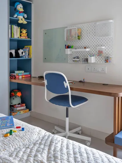 The study area in this kid's room includes a pegboard organizer and a glass writing board, creating a fun and functional workspace.
