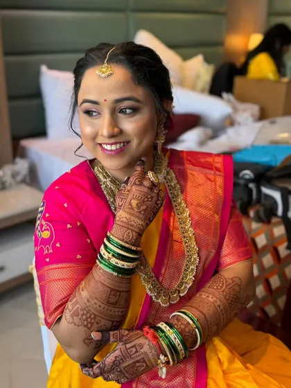 This close-up highlights the subtle detailing and natural glow of her bridal makeup. The look was designed to complement her intricate henna and traditional gold jewelry, creating a cohesive and elegant bridal style.