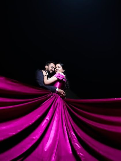 A dramatic shot with a flowing magenta gown. The makeup is designed to be as show-stopping as the dress.