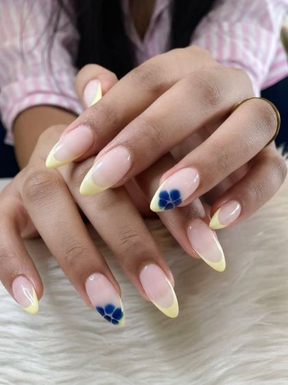 Another look at the yellow French tips with blue floral accents, perfect for a sunny day.