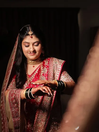A breathtaking traditional red ensemble for the reception. The makeup is timeless, with a focus on flawless skin and a classic bridal glow.