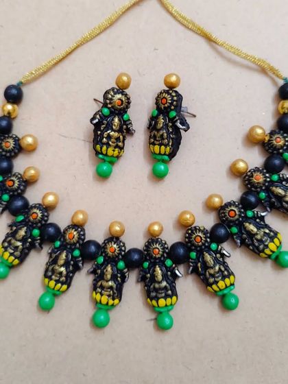 A beautiful Mahalakshmi temple necklace in a green, yellow, and black combination. These are lightweight and affordable, making them ideal for bulk orders for Varamahalakshmi festival gifts.