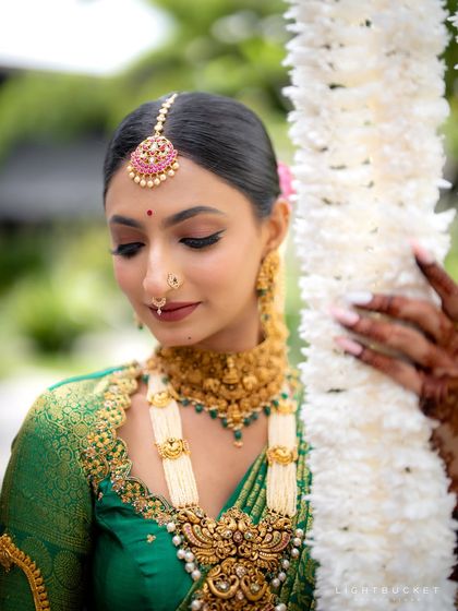 A close-up showcasing the delicate eye makeup, winged liner, and the traditional maang tikka. Every detail is meticulously handled.