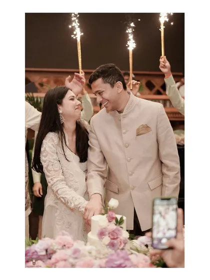 A celebratory cake-cutting moment from an engagement party. The sparklers held by friends and the couple's happy expressions perfectly capture the joy and excitement of this pre-wedding event.