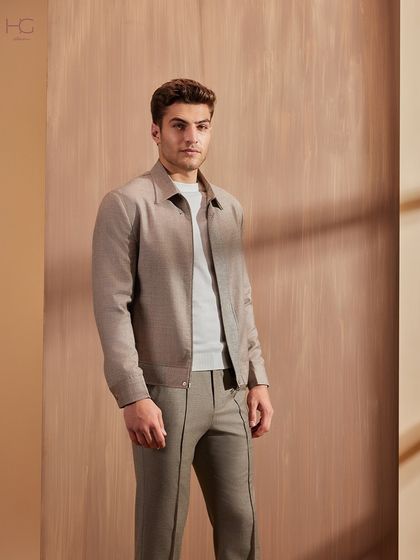 This neutral-toned zip-up jacket and matching trouser set makes a statement through its minimalist design and impeccable fit. It’s a sophisticated take on winter casuals.