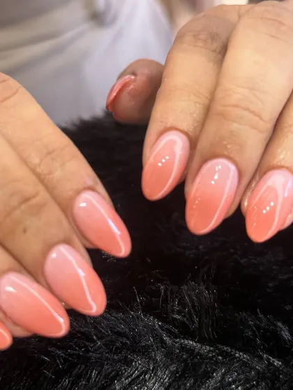 A beautiful coral ombre set. The smooth transition of color on these almond-shaped nails creates a warm and vibrant look perfect for any season.