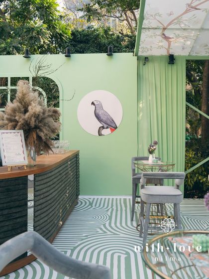 The custom-built bar in 'The Conservatory', featuring a parrot illustration that adds a touch of tropical whimsy to the chic design.