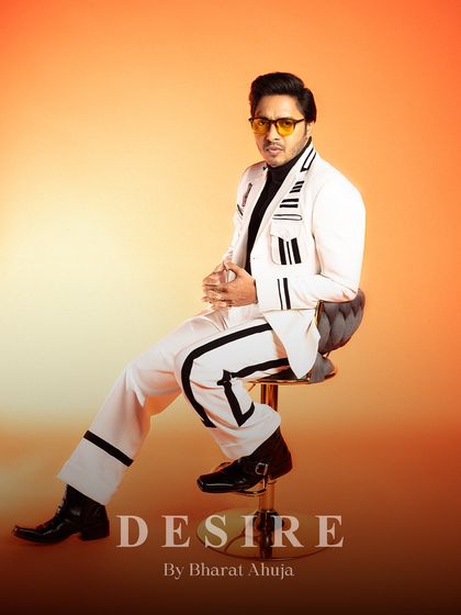 A final seated pose in the white and black striped suit, a testament to its timeless style and modern edge.
