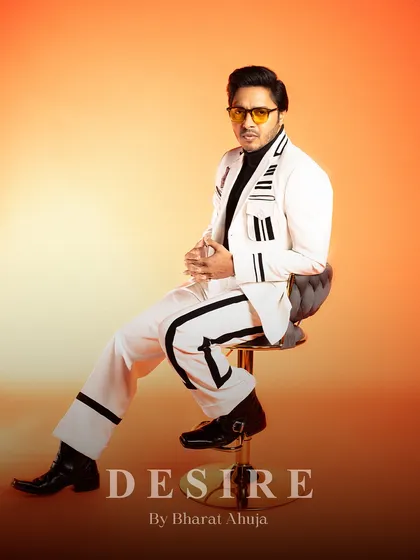 A final seated pose in the white and black striped suit, a testament to its timeless style and modern edge.