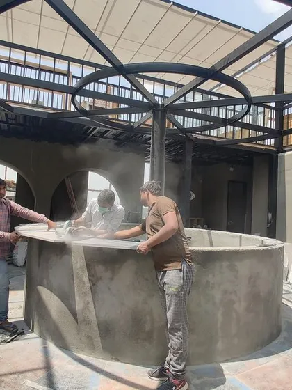 A work-in-progress shot of the rooftop bar, with the circular bar counter being finished and the metal framework for the roof in place.
