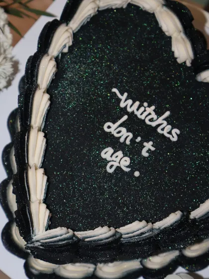 A close-up of our "witches don't age" cake, showing off the subtle green glitter that gives it a magical, sparkling finish.