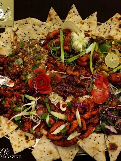 A vibrant and colorful thaal loaded with Chinese-style starters like chicken crispy and chili chicken, surrounded by naan. This platter shows my fusion offerings for group dining.