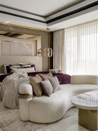 Comfort takes center stage in this luxurious master bedroom. We introduced a bold plum color in the bedding, a dramatic upholstered headboard with mirrored panels, and a plush, curved seating nook to make the room feel like a destination.