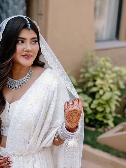 A beautiful outdoor shot of my bride in her white lehenga. The look is so serene and elegant, perfect for a daytime wedding ceremony.