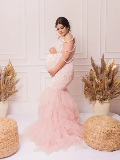A stunning profile shot of a client in our pink mermaid-style gown. The pearl-draped back is a unique and elegant detail.