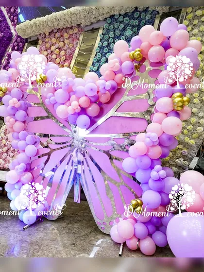 A large, stunning butterfly prop made of pink and purple balloons with silver accents. This piece serves as a fantastic photo opportunity and a central decorative element.