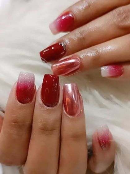 A glamorous combination of red nails, including a red-to-white ombré and a stunning red chrome accent nail.