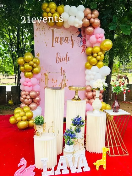An outdoor 'Bride to Be' setup for a bridal shower. The pink and gold balloon arch and custom name sign create a perfect photo spot.