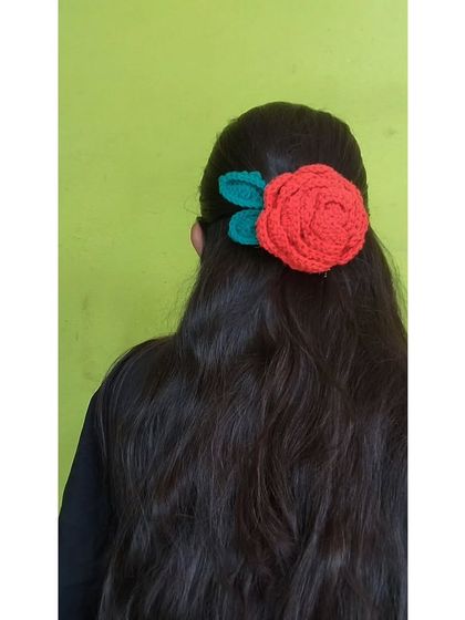 The crochet rose hairclip styled with long, flowing hair.