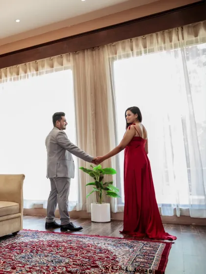 A quiet dance by the window. The couple holds hands against the soft light, creating an intimate and romantic silhouette that speaks volumes.