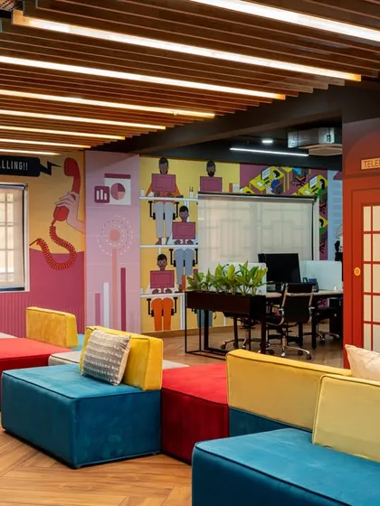 Workspaces should be fun. For this tech office, we created a vibrant breakout area with colorful modular seating, custom wall graphics, and a classic red London phone booth for private calls, injecting energy and brand personality into the workplace.