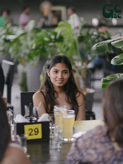 A candid shot of a guest enjoying a conversation with friends over a couple of beers.