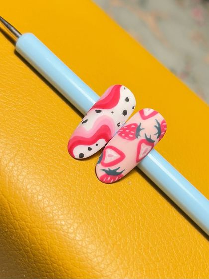 A sweet and berrylicious design. These nails feature hand-painted strawberries and abstract pink swirls for a fun and fruity theme.