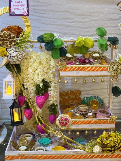A grand, multi-tiered Diwali hamper filled with an assortment of traditional decorations, bangles, and treats. The miniature lanterns add a warm, festive glow to this magnificent arrangement.