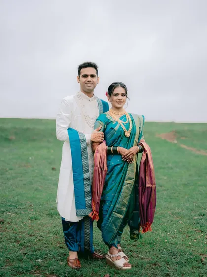 A classic full-length portrait of the couple in their stunning traditional Maharashtrian attire. The wide-open landscape provides a simple yet powerful backdrop.