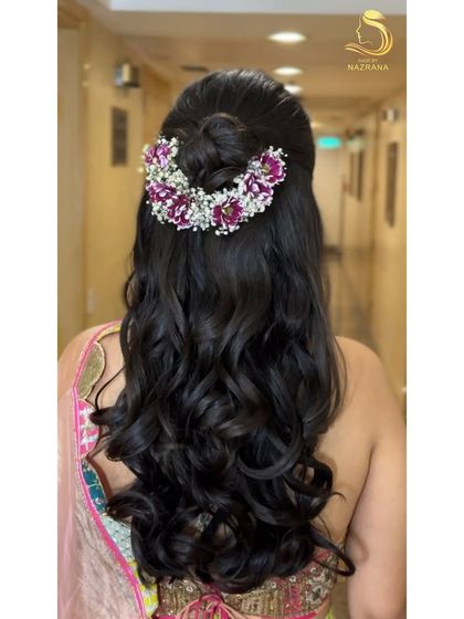 A back view of the half-up top knot with a crown of purple and white flowers.