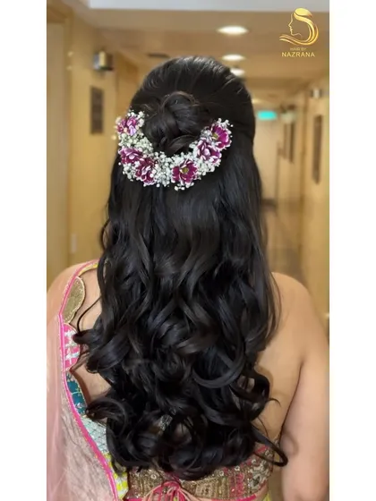 A back view of the half-up top knot with a crown of purple and white flowers.