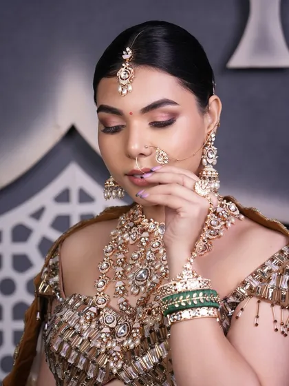 The elegance of a clean bun allows the focus to remain on the bride's expressive eyes and intricate jewelry, making it a perfect choice for a classic bridal portrait.