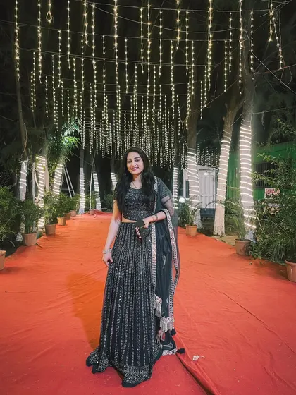 A photo of my partner on the red carpet entrance, surrounded by a canopy of beautiful fairy lights.