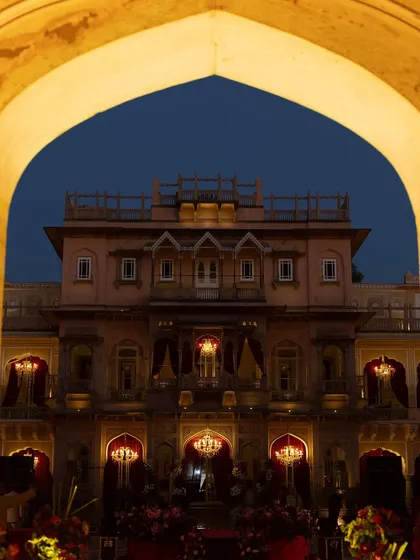 A view of the palace at twilight, framed by an archway. The deep blue sky contrasts beautifully with the warm, golden light of the venue, creating a magical atmosphere.
