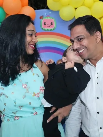 A happy family celebrating their son Yuvanth's Cocomelon-themed first birthday party.