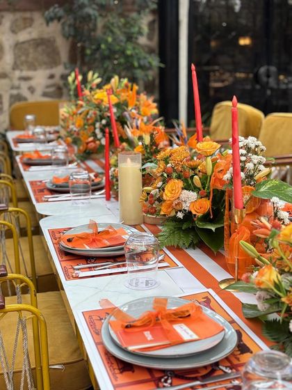 Another view of the elegant table setting, showing the repetition of orange candles and floral arrangements that created a cohesive and luxurious look.