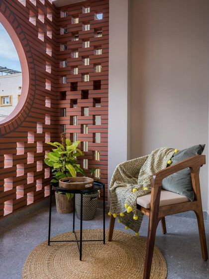 A detail shot of the balcony reading corner, showing how a simple wooden chair and a few plants can create a serene and personal space.