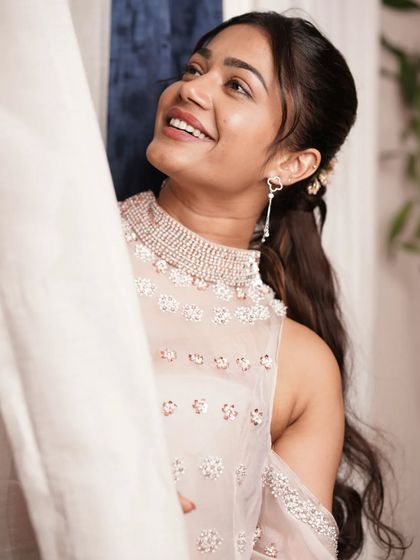 A candid shot capturing the grace of the outfit. The cold-shoulder design and intricate neckline make it a standout piece for any formal day event or press conference.