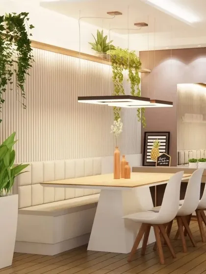 A unique dining setup with a cushioned bench against a fluted wall panel. The hanging plants and modern light fixture add a touch of nature and contemporary style.