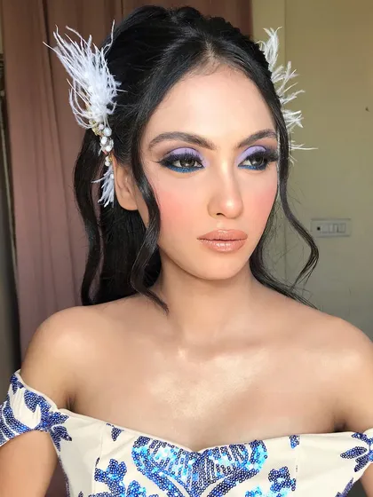 The feather hair accessories add a touch of whimsy and elegance to this unique cocktail glam.