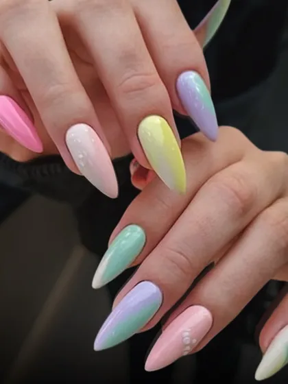 Pastel rainbow nails are a fun and dreamy choice. This set features a soft gradient of pastel colors on long, almond-shaped nails for a whimsical look.