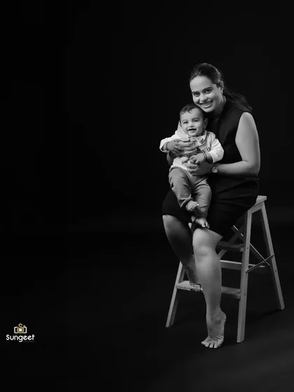 A beautiful and simple mother and child portrait in black and white. The minimalist setup puts all the focus on the mother's loving smile and her happy, comfortable baby.
