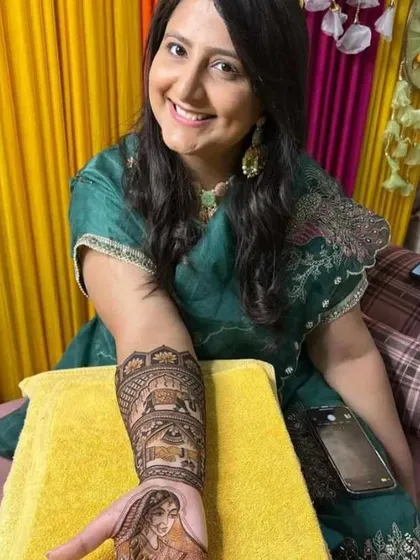 This happy bride is showing the portrait mehandi on her palm. I specialize in creating custom portraits that add a deeply personal touch to your bridal henna.